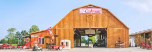 Cashmans storefront, a wooden barn with the Cashmans sign and farm equipment out front